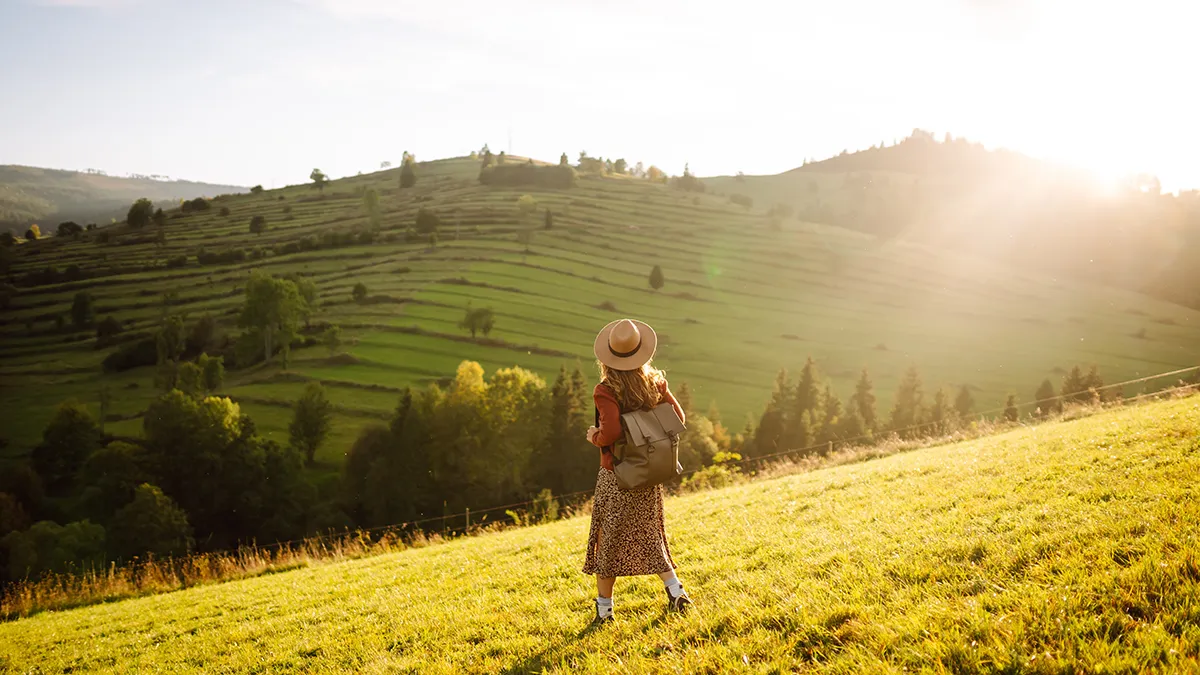 A woman walking on gorgeous green hills